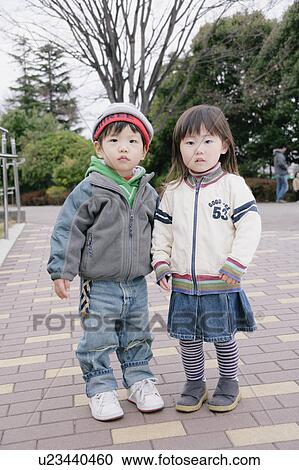 Stock Image - Portrait of boy and girl standing. Fotosearch