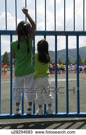 Rear view of girls standing View Large Photo Image Stock Image - Rear view of girls standing. Fotosearch