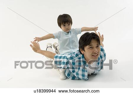 Son sitting on father's back View Large Photo Image Picture - Son sitting on father's back. Fotosearch