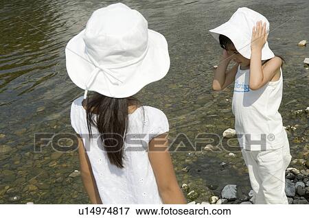 Stock Photo - Two girls playing by river. Fotosearch