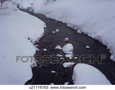 Stock Image - Snow covered land and river. Fotosearch