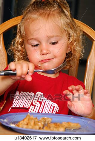 Close-up of a girl eating a pie with a fork View Large Photo Image Stock Photo - Close-up of a girl eating a pie with a fork. Fotosearch