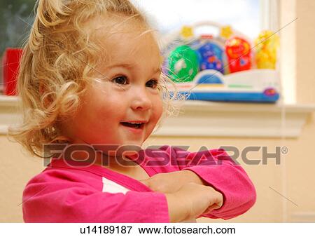 Stock Photo - Close-up of a girl smiling and looking away. Fotosearch