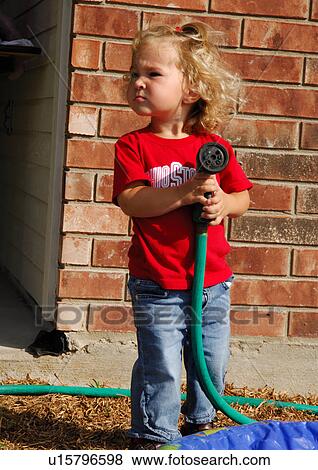 Close-up of a girl standing and holding a hose pipe View Large Photo Image Stock Photo - Close-up of a girl standing and holding a hose pipe. Fotosearch