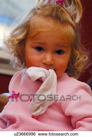 Stock Photograph - Portrait of a girl holding a sock in her mouth. Fotosearch