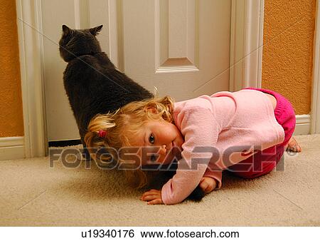 Portrait of a girl playing with a cat View Large Photo Image Stock Photograph - Portrait of a girl playing with a cat. Fotosearch