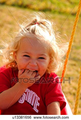 Portrait of a girl smiling with her fingers in her mouth View Large Photo Image Stock Photograph - Portrait of a girl smiling with her fingers in her mouth. Fotosearch