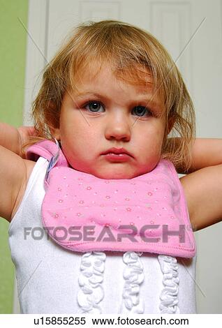 Stock Photography - Portrait of a girl wearing a baby bib. Fotosearch