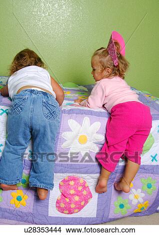Rear view of two girls climbing on the bed View Large Photo Image Picture - Rear view of two girls climbing on the bed. Fotosearch
