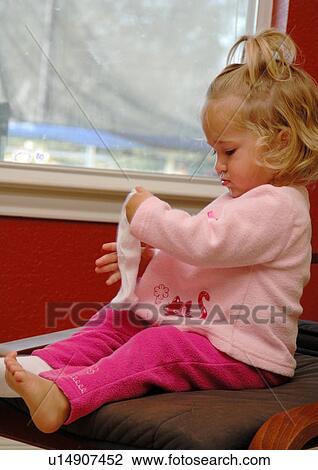 Stock Image - Side profile of a girl holding a sock. Fotosearch
