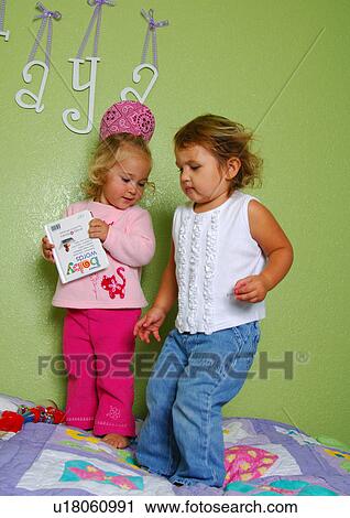 Two girls standing on the bed and playing View Large Photo Image Stock Image - Two girls standing on the bed and playing. Fotosearch