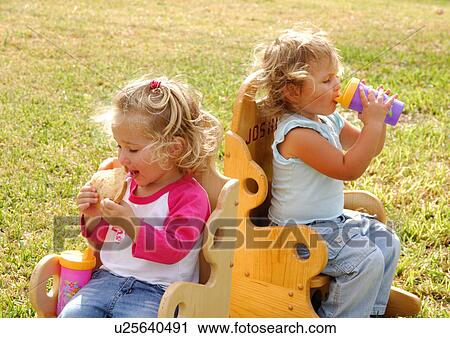 Close-up of a girl eating a slice of bread and her sister drinking water from a bottle View Large Photo Image Stock Image - Close-up of a girl eating a slice of bread and her sister drinking water from a bottle. Fotosearch