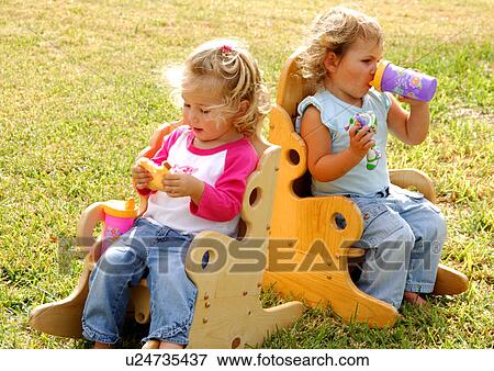 Close-up of a girl eating a slice of bread and her sister drinking water from a bottle View Large Photo Image Stock Photo - Close-up of a girl eating a slice of bread and her sister drinking water from a bottle. Fotosearch