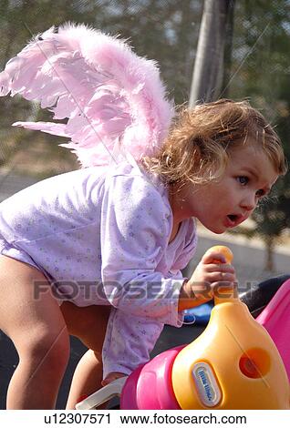 Close-up of a girl picking up a tricycle View Large Photo Image Stock Image - Close-up of a girl picking up a tricycle. Fotosearch
