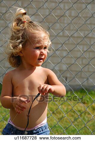 Stock Photo - Close-up of a girl standing and looking sideways. Fotosearch