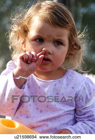 Close-up of a girl with her finger in her mouth View Large Photo Image Picture - Close-up of a girl with her finger in her mouth. Fotosearch
