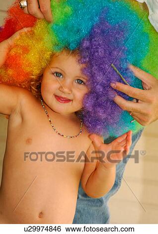 Close-up of a person adjusting a multi-colored wig on a girl's head View Large Photo Image Stock Photograph - Close-up of a person adjusting a multi-colored wig on a girl's head. Fotosearch