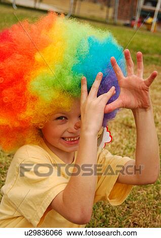 Portrait of a boy wearing a multi-colored wig and making a face View Large Photo Image Stock Photograph - Portrait of a boy wearing a multi-colored wig and making a face. Fotosearch