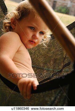 Stock Photograph - Side profile of a girl sitting in a hammock. Fotosearch