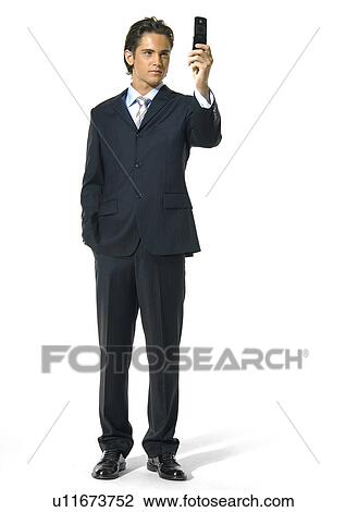 Stock Image - Businessman text messaging with a mobile phone. Fotosearch