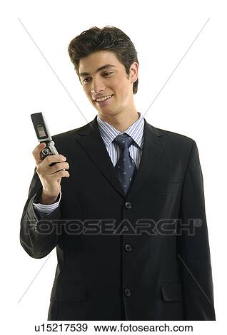 Businessman text messaging with a mobile phone and smiling View Large Photo Image Stock Photo - Businessman text messaging with a mobile phone and smiling. Fotosearch