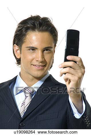 Picture - Close-up of a businessman text messaging with a mobile phone and smiling. Fotosearch