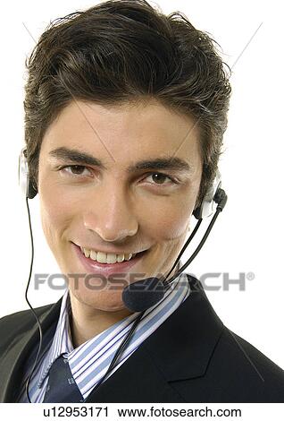 Stock Image - Portrait of a businessman wearing a headset and smiling. Fotosearch