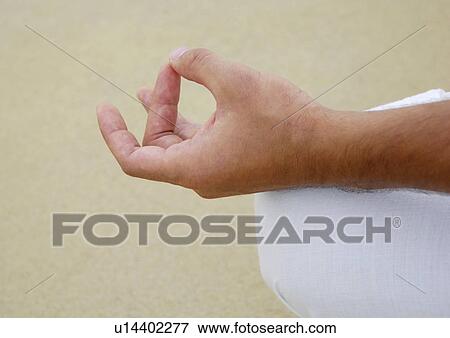 Stock Photo - Close-up of a person's hand in the lotus position. Fotosearch
