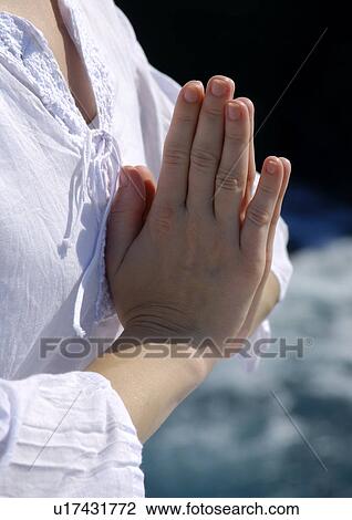 Stock Image - Close-up of a woman practicing yoga in a prayer position. Fotosearch