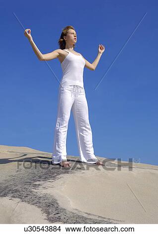 Low angle view of a young woman practicing yoga View Large Photo Image Picture - Low angle view of a young woman practicing yoga. Fotosearch