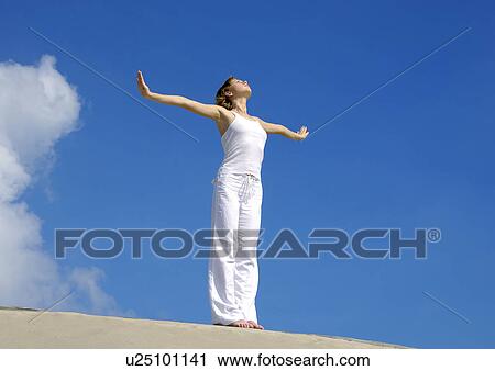 Low angle view of a young woman practicing yoga View Large Photo Image Stock Image - Low angle view of a young woman practicing yoga. Fotosearch