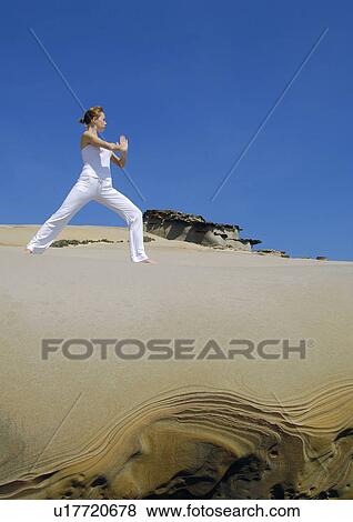 Stock Photo - Low angle view of a young woman practicing yoga. Fotosearch
