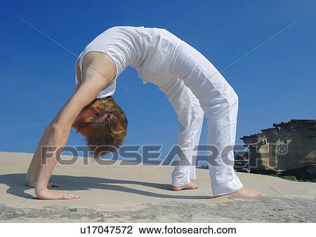Side profile of a young woman bending over backward View Large Photo Image Stock Image - Side profile of a young woman bending over backward. Fotosearch