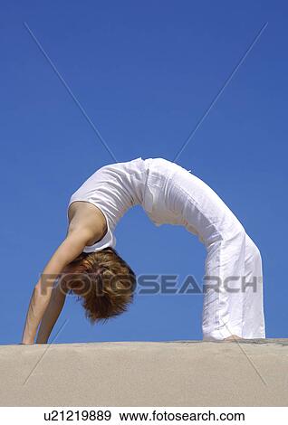 Side profile of a young woman bending over backward View Large Photo Image Stock Photo - Side profile of a young woman bending over backward. Fotosearch