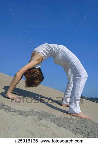 Side profile of a young woman bending over backward View Large Photo Image Stock Photograph - Side profile of a young woman bending over backward. Fotosearch