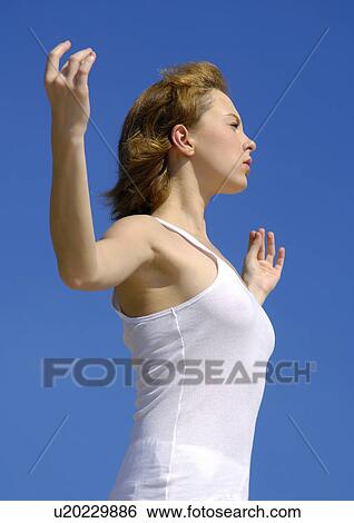 Stock Photograph - Side profile of a young woman practicing yoga. Fotosearch