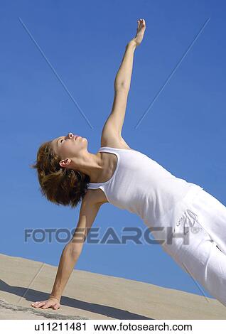 Young woman practicing yoga in the side plank pose View Large Photo Image Stock Image - Young woman practicing yoga in the side plank pose. Fotosearch