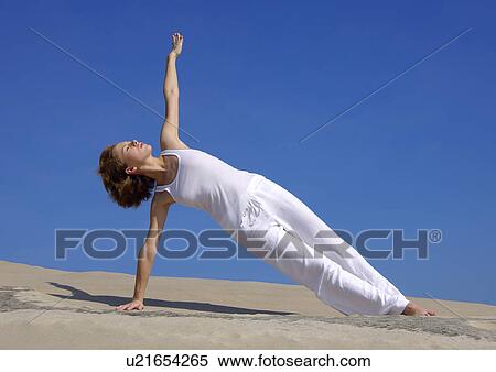 Young woman practicing yoga in the side plank pose View Large Photo Image Stock Photography - Young woman practicing yoga in the side plank pose. Fotosearch