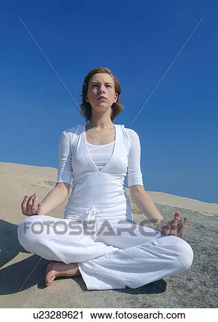 Young woman practicing yoga in the lotus position View Large Photo Image Stock Image - Young woman practicing yoga in the lotus position. Fotosearch