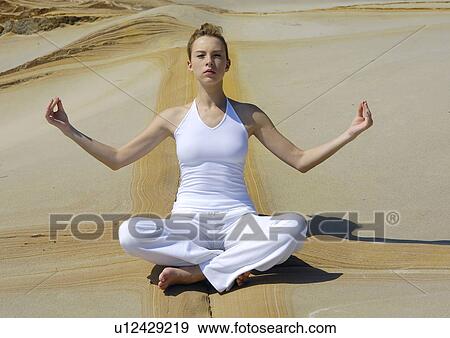 Young woman practicing yoga in the lotus position View Large Photo Image Stock Photo - Young woman practicing yoga in the lotus position. Fotosearch