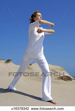 Stock Image - Young woman practicing yoga. Fotosearch