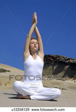 Stock Photo - Young woman practicing yoga with her arms crossed. Fotosearch