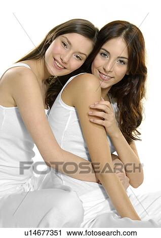 Stock Image - Portrait of a young woman hugging another young woman. Fotosearch