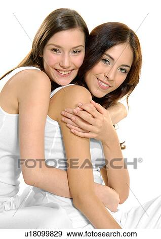 Stock Photo - Portrait of a young woman hugging another young woman. Fotosearch
