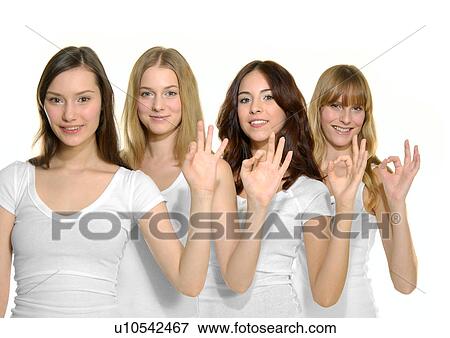 Stock Photo - Portrait of four young women standing together and making an ok sign. Fotosearch