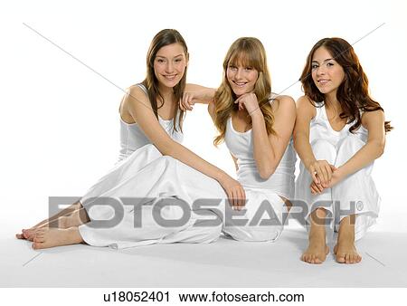 Portrait of three young women sitting together and smiling View Large Photo Image Stock Image - Portrait of three young women sitting together and smiling. Fotosearch