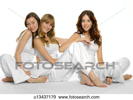 Stock Photo - Portrait of three young women sitting together and smiling. Fotosearch