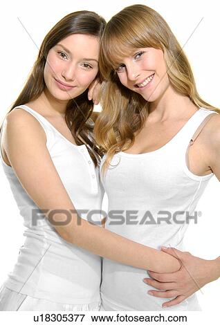 Stock Photo - Portrait of two young women hugging each other. Fotosearch