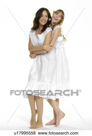 Stock Photo - Portrait of a young woman hugging another young woman and smiling. Fotosearch
