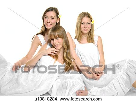Portrait of three young women sitting together and smiling View Large Photo Image Picture - Portrait of three young women sitting together and smiling. Fotosearch